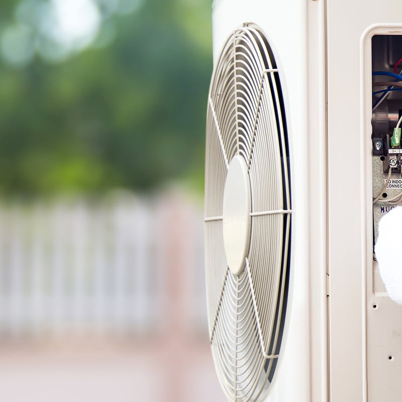 Maintenance d'un climatiseur extérieur. L'unité montre son ventilateur et le panneau électrique ouvert avec raccordement des fils aux bornes 1, 2, N, G.